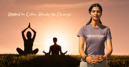 Unshaken T-Shirt model meditating in sunlight next to two silhouetted yogis at sunrise, with the text “Rooted in Calm. Ready for Change.” in the background.