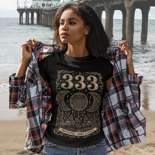Woman wearing 333 black angel number meditation shirt at beach pier — Dark Sacred Stillness collection by Ramro Yoga Wear