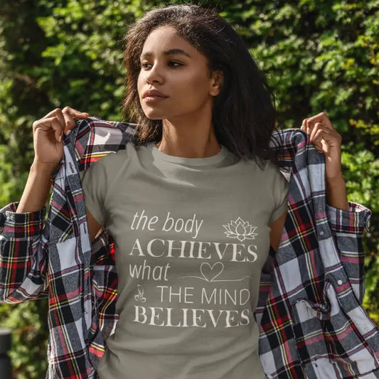 Woman wearing Achieve T-Shirt Heather Military Green outdoors, hand raised, trees in background by Ramro Yoga Wear from The Vault Collection