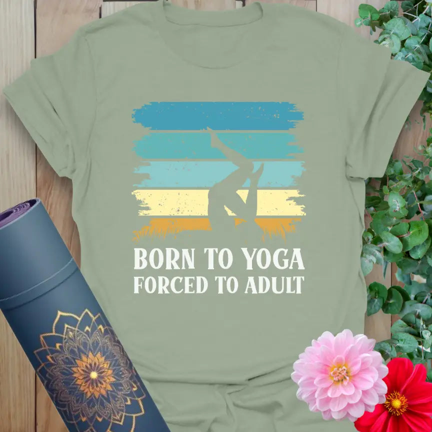 Flatlay of sage green Adult T-Shirt with playful yoga quote design, “Born to Yoga, Forced to Adult.” With love and gratitude from Ramro Yoga Wear.