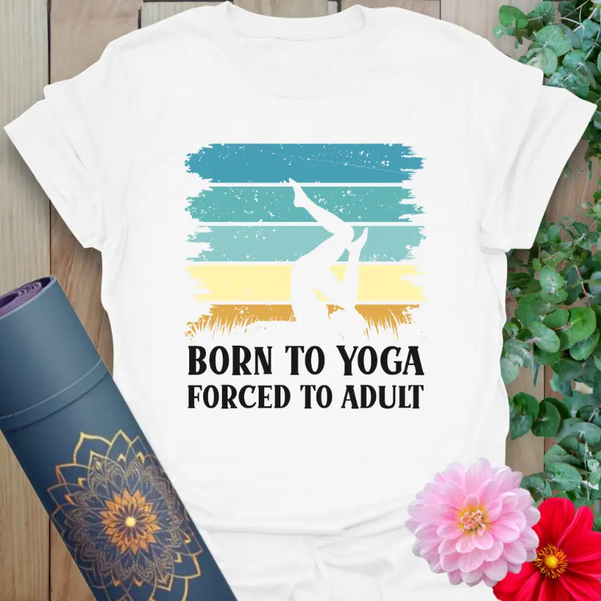 Flatlay of white Adult T-Shirt with colorful yoga-inspired quote, “Born to Yoga, Forced to Adult.”