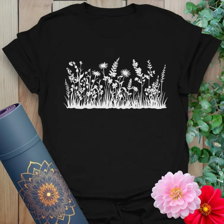 Classic black cotton yoga t-shirt showcasing blooming field flowers and grasses symbolizing natural harmony and soulful movement.
