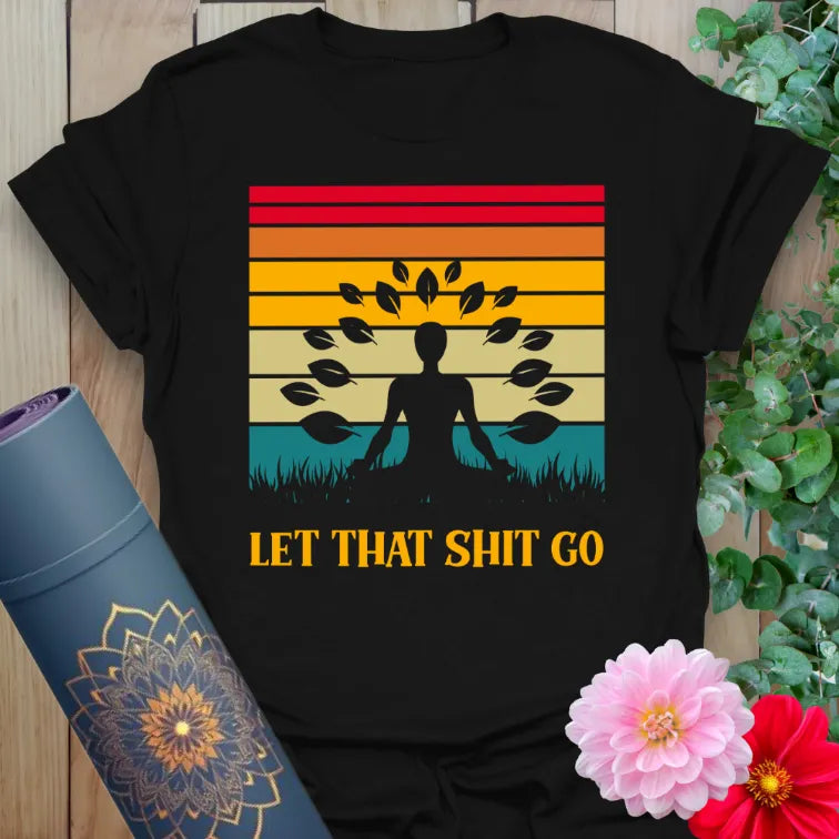 Classic black cotton yoga t-shirt showcasing colorful retro sunset, meditating yogi, and humorous letting-go mantra.