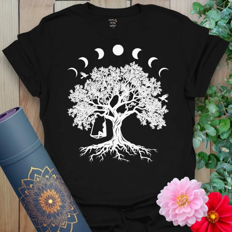 Classic black cotton yoga t-shirt showcasing majestic tree, lunar cycles, and playful swing symbolizing cosmic connection and soulful living.