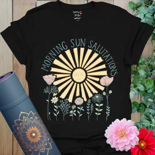 Black Morning Sun Salutations T-Shirt with glowing sunrise and pastel flowers. A balanced, radiant yoga design with peaceful energy.