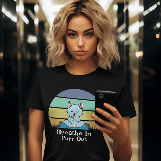 Woman wearing Black Breathe In T-Shirt featuring retro yoga cat artwork in warm editorial lifestyle setting.