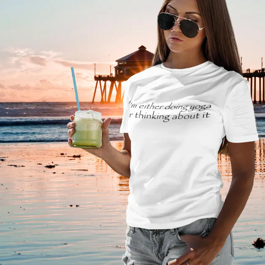 Woman wearing Doing Yoga White T-Shirt at the beach at sunset — The Vault collection by Ramro Yoga Wear