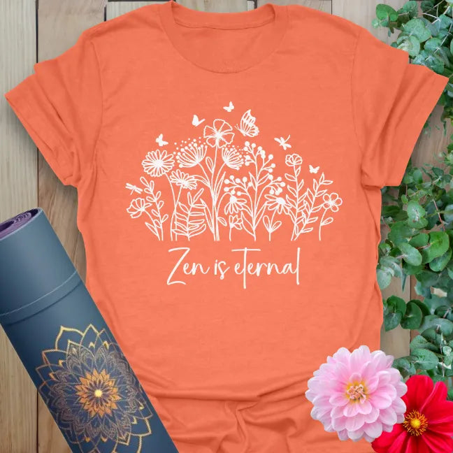 Vibrant orange yoga t-shirt featuring "Zen is Eternal" floral design for meditation and joyful living.