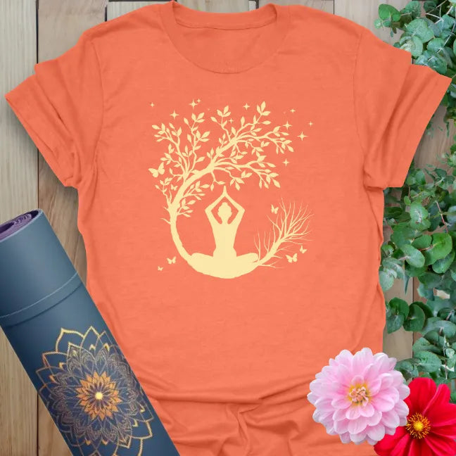 Vibrant orange yoga t-shirt featuring evening meditation scene with tree of life and crescent moon design.