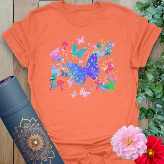 Vibrant orange yoga t-shirt showcasing colorful butterfly design for playful, soulful living and mindful movement.