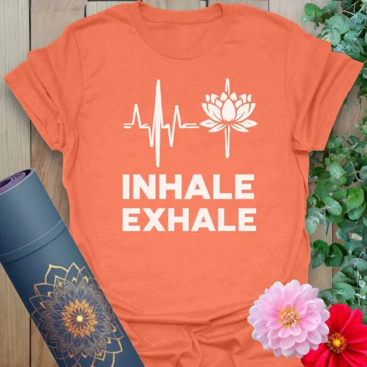 Vibrant orange yoga t-shirt showcasing heart and lotus graphic with "Inhale Exhale" quote for soulful, conscious living.