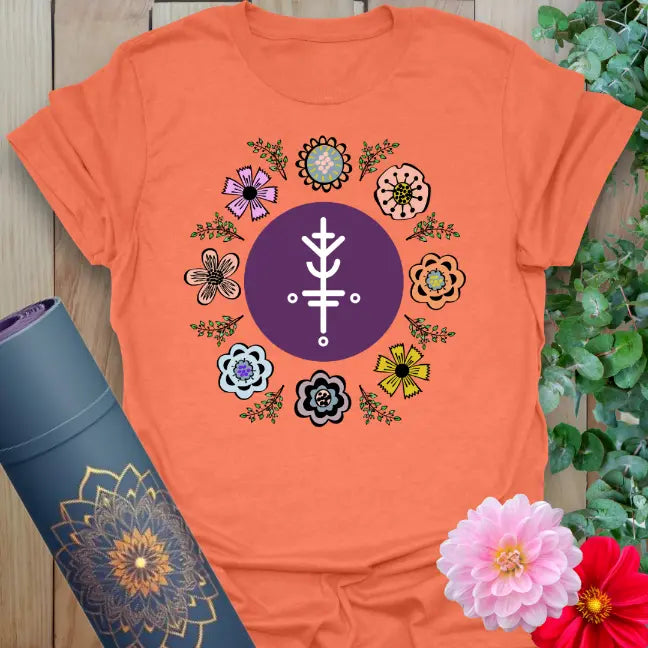 Vibrant orange yoga t-shirt showcasing playful flower circle and positive sacred symbol design for soulful abundance.