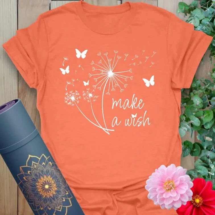 Vibrant orange yoga t-shirt showcasing dreamy dandelion and butterfly artwork with "Make a Wish" quote for soulful living.