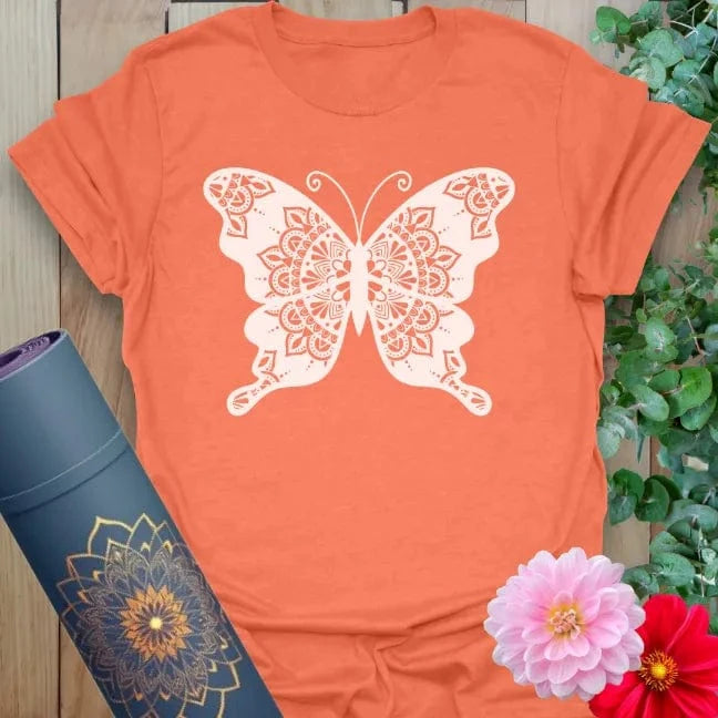 Vibrant orange yoga t-shirt showcasing sacred mandala butterfly artwork inspiring freedom, mindfulness, and spiritual beauty.