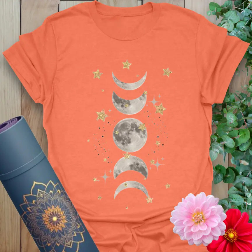 Vibrant orange yoga t-shirt showcasing mystical moon phases and starry artwork inspiring intuitive, mindful living.