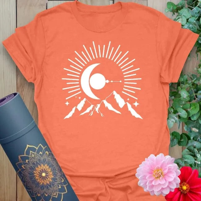 Vibrant orange yoga t-shirt showcasing bold crescent moon and mountain design inspiring mindful strength and adventurous spirit.