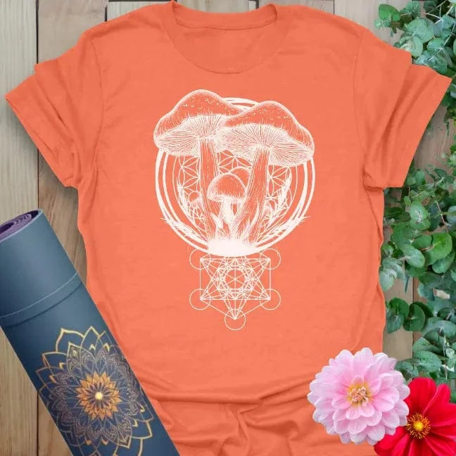 Vibrant orange yoga t-shirt showcasing sacred mushrooms and geometric root design inspiring soulful living and nature-centered growth.