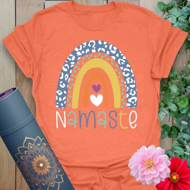 Vibrant orange yoga t-shirt showcasing whimsical rainbow design and heartfelt Namaste message for soulful positivity.