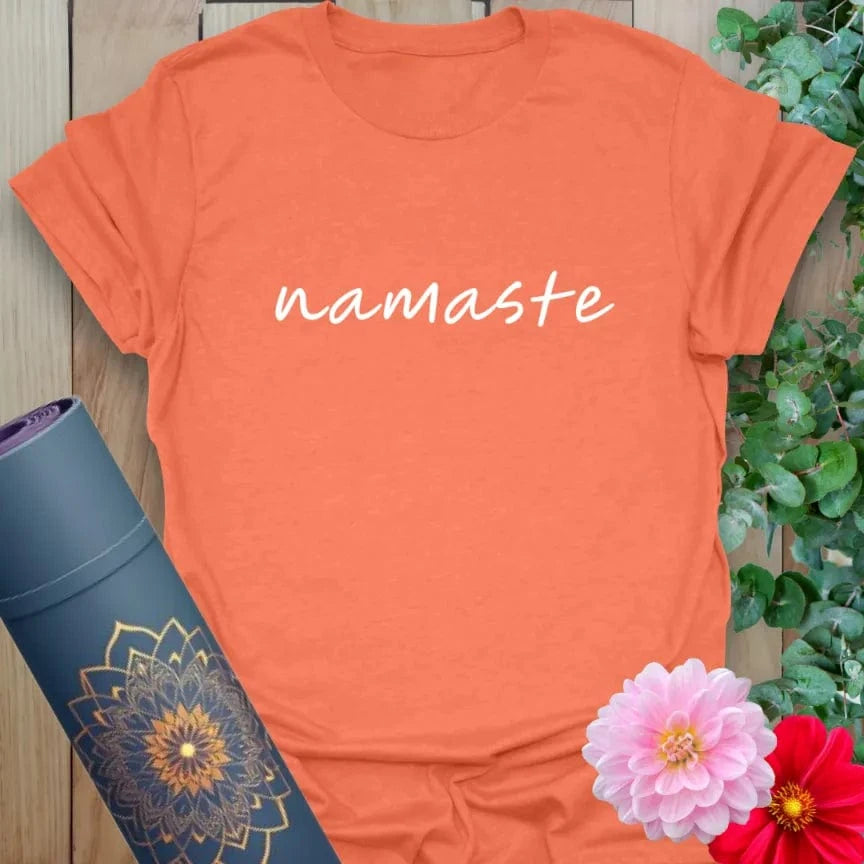 Vibrant orange yoga t-shirt showcasing elegant "namaste" handwriting design inspiring mindfulness and gratitude.