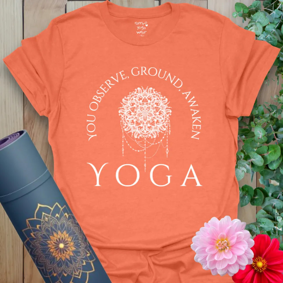Vibrant orange yoga t-shirt showcasing inspirational mindful living message and sacred dreamcatcher design for soulful presence and heart-centered growth.