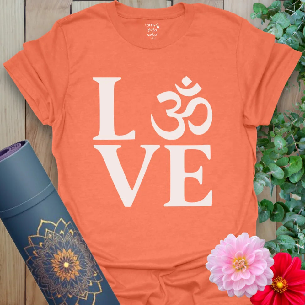 Vibrant orange yoga t-shirt showcasing bold LOVE and Om symbol artwork for conscious, heart-centered movement and spiritual growth.