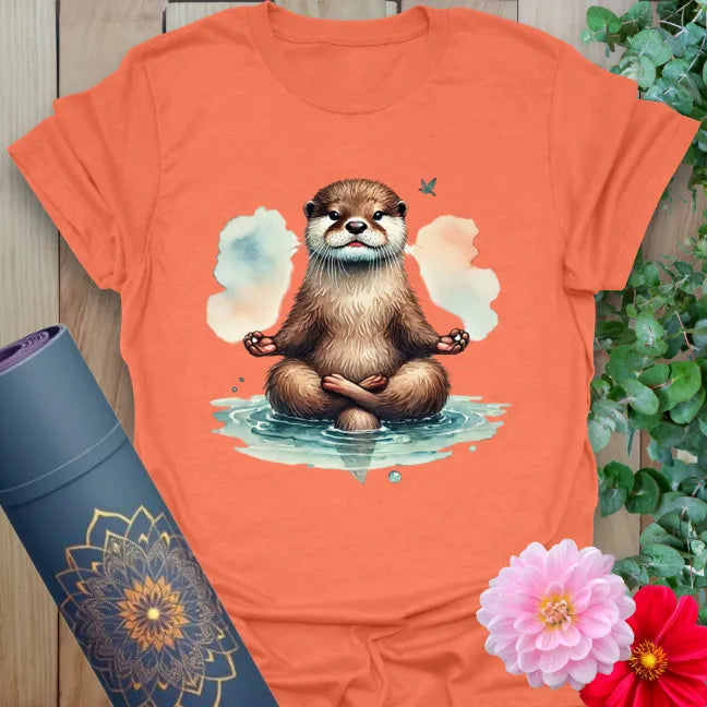 Vibrant orange yoga t-shirt showcasing adorable otter in meditation pose surrounded by clouds for soulful, joyful energy.