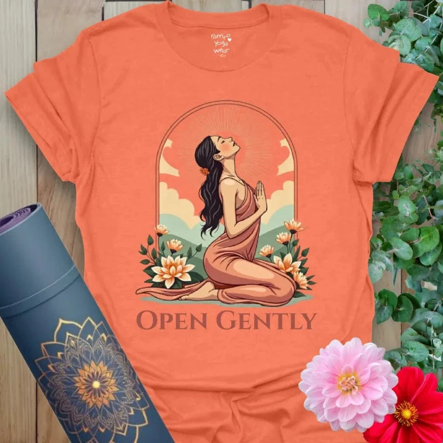 Vibrant orange yoga t-shirt showcasing graceful yogi heart-opener artwork with blooming flowers and soft skies.