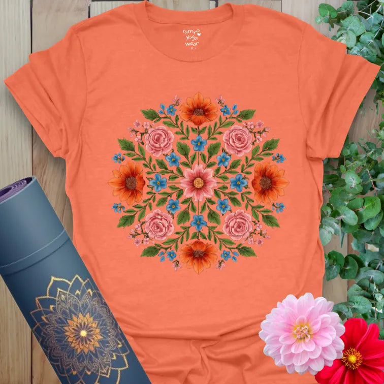 Vibrant orange yoga t-shirt showcasing colorful floral prism artwork inspiring joyful, nature-connected mindfulness.