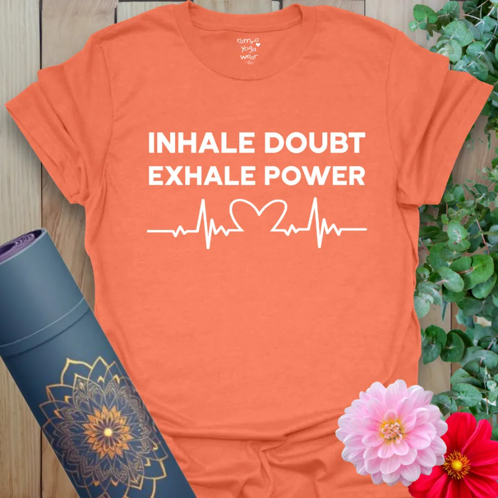 Vibrant orange yoga t-shirt showcasing motivational mantra and heartbeat design inspiring strong, conscious movement.