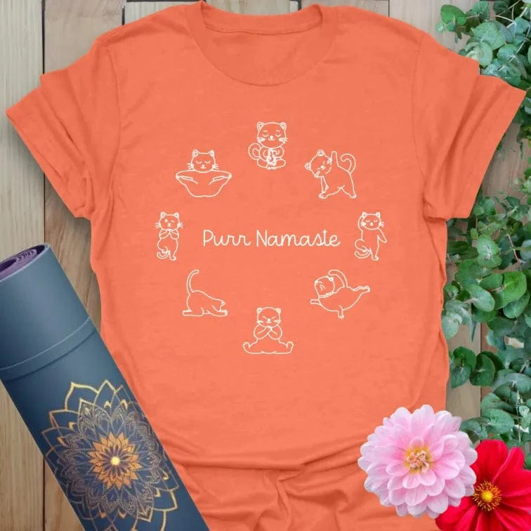 Vibrant orange yoga t-shirt showcasing charming cat yoga artwork inspiring conscious movement and lighthearted mindfulness.