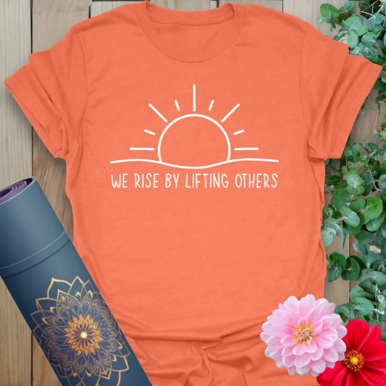 Vibrant orange yoga t-shirt showcasing inspirational sunrise design encouraging kindness, conscious movement, and mindful action.