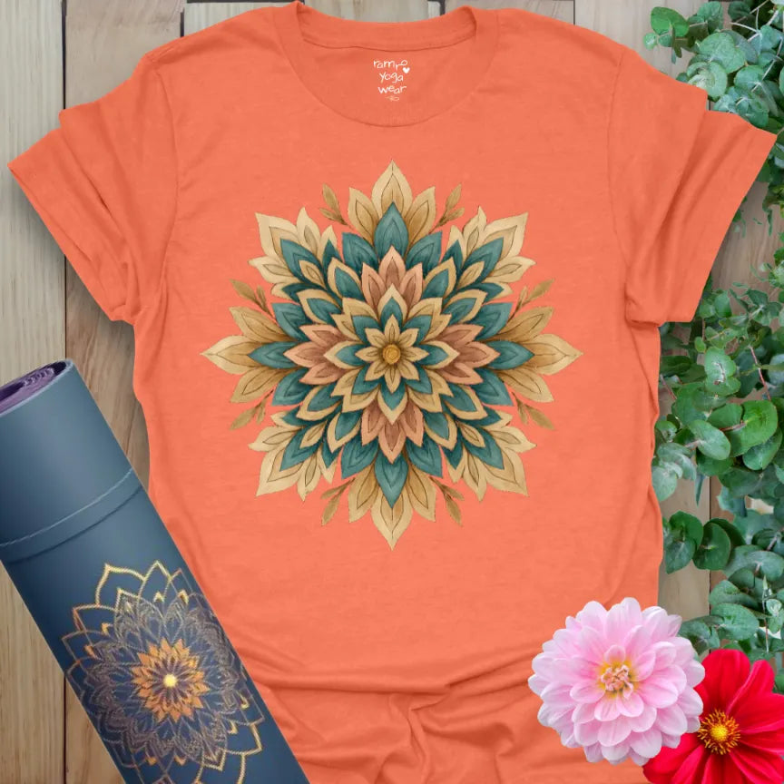 Vibrant orange yoga t-shirt showcasing earthy mandala floral artwork for conscious blooming and soulful movement.