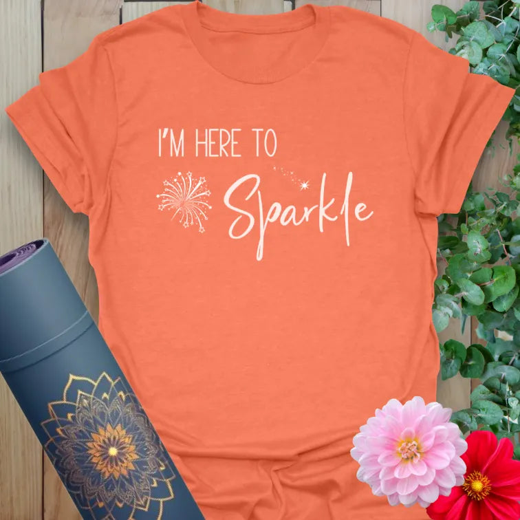 Vibrant orange yoga t-shirt showcasing uplifting sparkle message for conscious movement and positive self-expression.