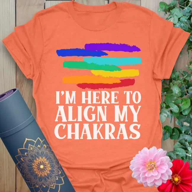 Vibrant orange yoga t-shirt with playful rainbow strokes and chakra alignment quote for soulful, humorous mindfulness.