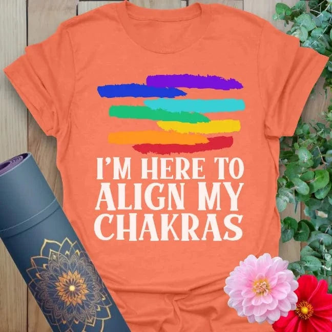 Vibrant orange yoga t-shirt with playful rainbow strokes and chakra alignment quote for soulful, humorous mindfulness.