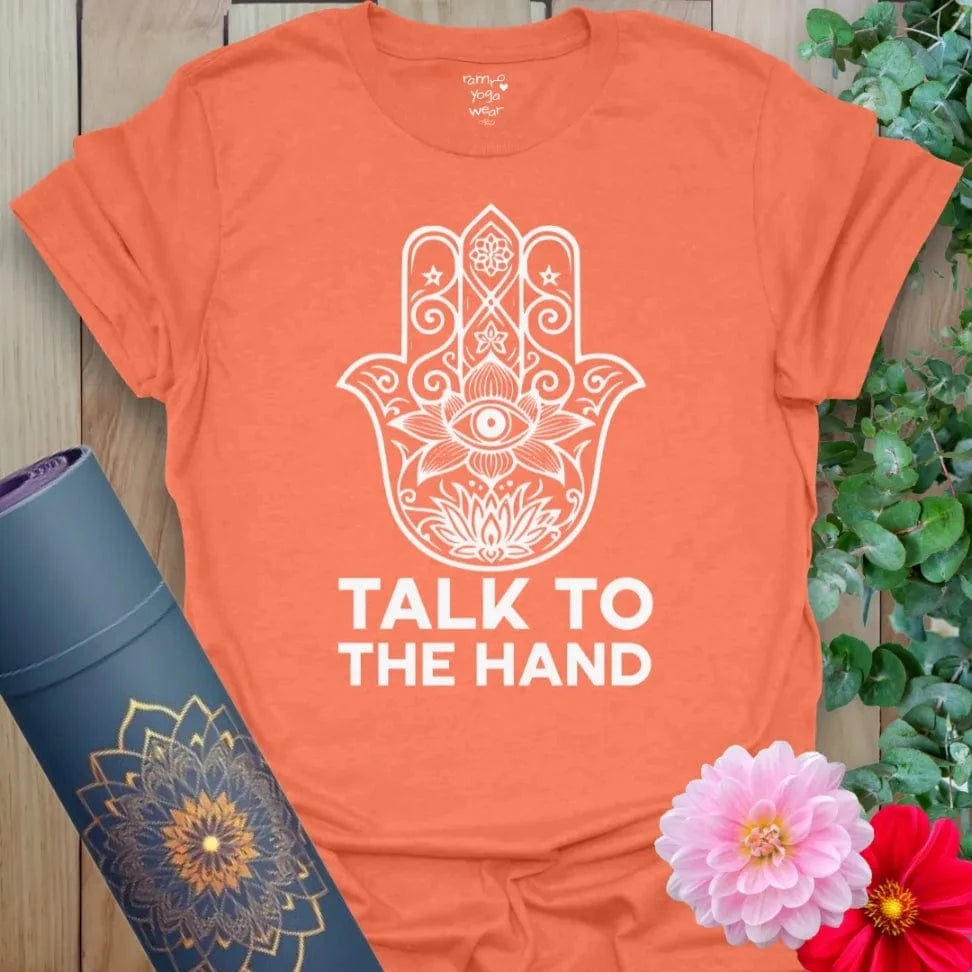 Vibrant orange t-shirt featuring white Hamsa graphic and cheeky yoga mantra for conscious, comedic wear.