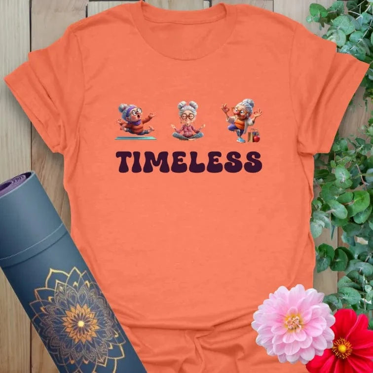 Vibrant orange tee featuring senior women in yoga and dance poses with bold lettering for spirited and active living.