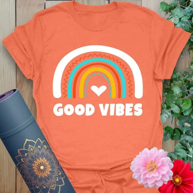 Vibrant orange t-shirt with heart-centered rainbow design and positive quote for radiant, uplifting yoga wear.