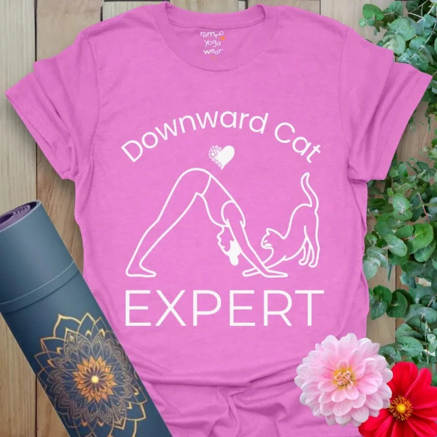 Heather Radiant Orchid Cat Expert T-Shirt with cat-themed yoga design, featuring yogi and cat interaction, slogan "Downward Cat Expert."