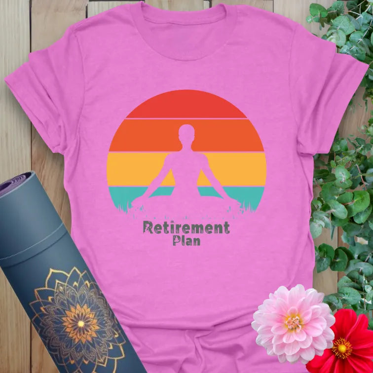 Radiant orchid-colored yoga tee with peaceful meditation figure and "Retirement Plan" design celebrating conscious, joyful living.