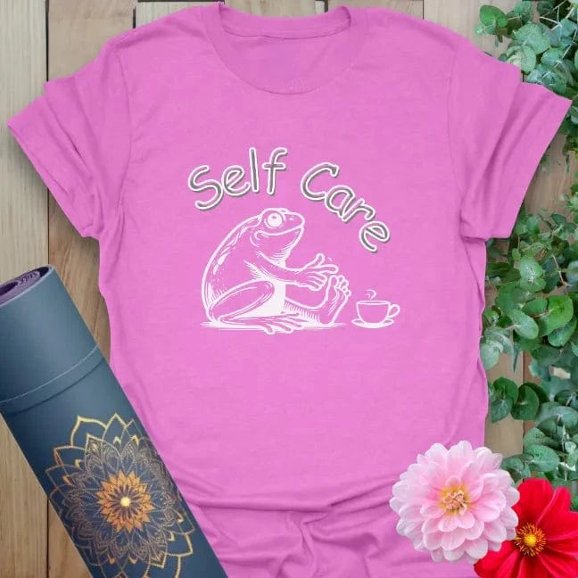 Radiant orchid-colored yoga tee with charming "Self Care" frog artwork promoting peaceful vibes and conscious chill.