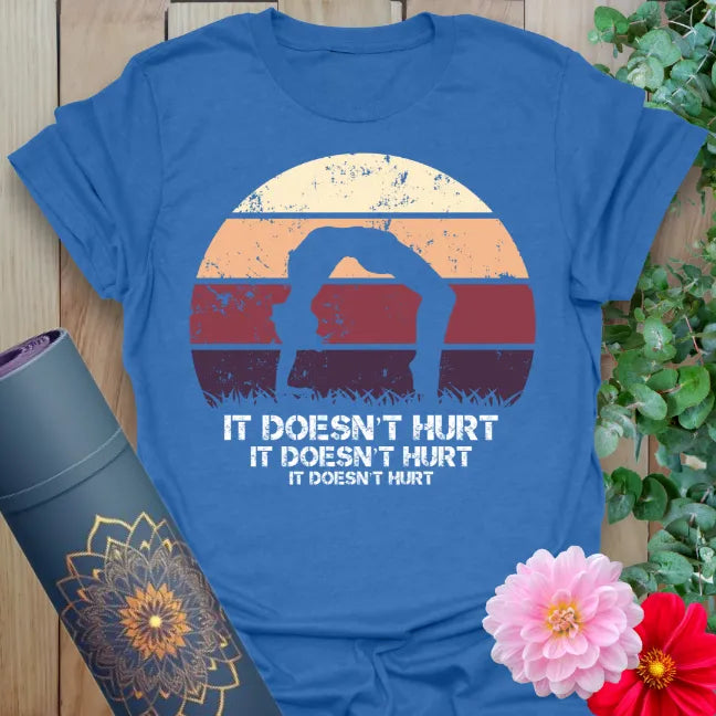 Soft cotton unisex yoga t-shirt featuring funny "It Doesn't Hurt" mantra with yogi backbend pose and retro sunset for mindful, joyful living.