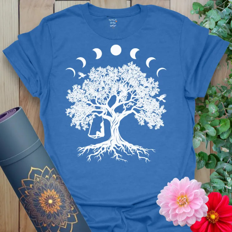 Soft cotton unisex yoga t-shirt featuring tree of life with lunar phases and swinging figure symbolizing mindful joy and cosmic balance.