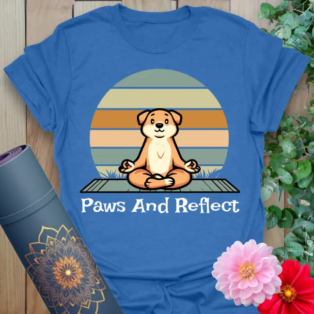 Soft cotton unisex yoga t-shirt featuring meditating dog illustration and "Paws and Reflect" quote for mindful, playful living.