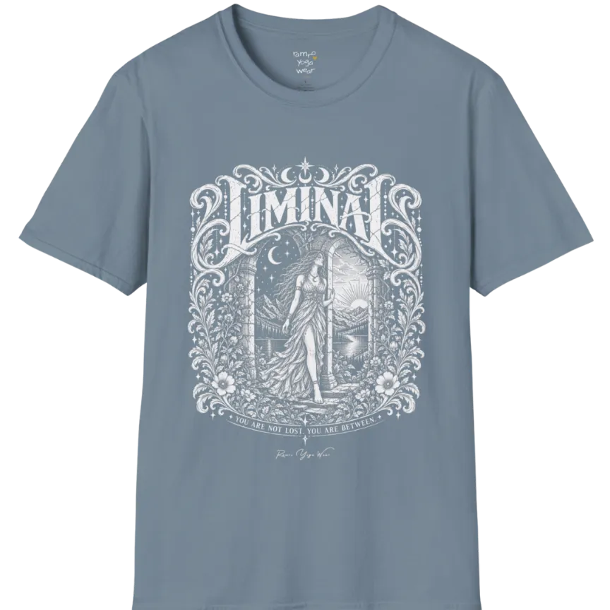 A short sleeved tee called the Liminal T-Shirt, flat lay and a soft cotton shirt. Simply says, 'You are not lost. You are between.' Design highlights ornate white LIMINAL lettering framed by flourishes and wild florals, with a robed figure standing in an arched doorway beneath a crescent moon and stars. Color is Stone Blue.