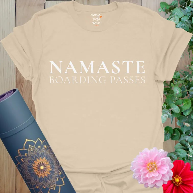 Sand Boarding Passes T-Shirt with minimalist serif text reading "NAMASTE Boarding Passes." Calm yoga travel shirt with flowers and mat.