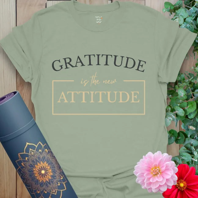 Sage green tee with the words "Gratitude is the New Attitude." Earthy tone for peaceful vibes and positive perspective.