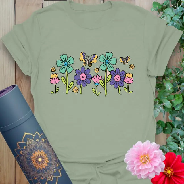 Sage green t-shirt with colorful nature-inspired flower and butterfly artwork