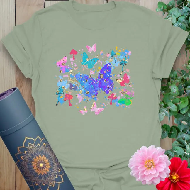 Calm sage green yoga t-shirt featuring colorful butterfly-inspired artwork symbolizing transformation and natural flow.