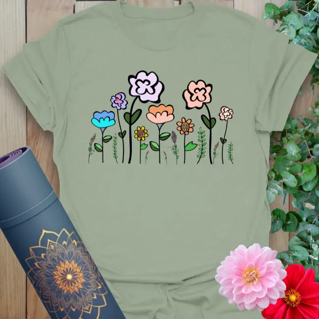 Calm sage green yoga t-shirt featuring delicate colorful flower illustration for grounded, nature-loving mindfulness.